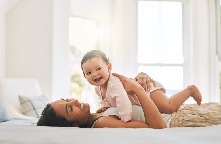 Mom and baby in bed smiling
