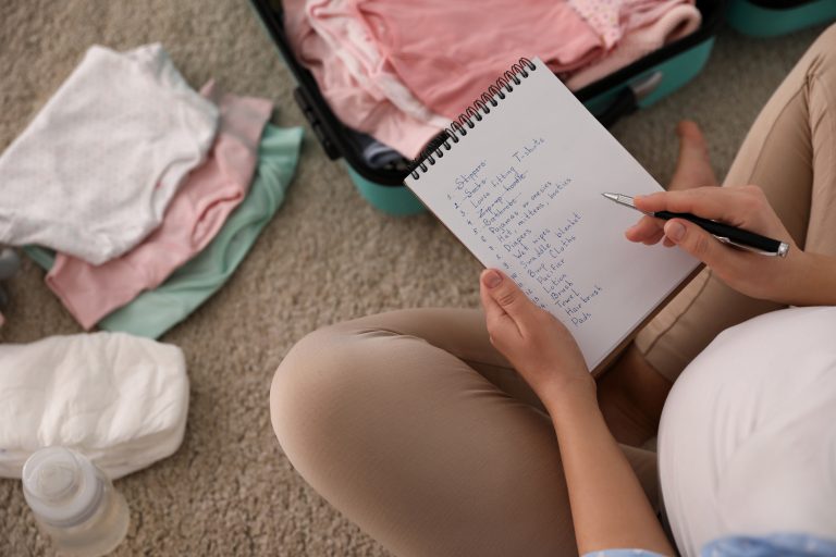 Pregnant woman writing hospital bag list