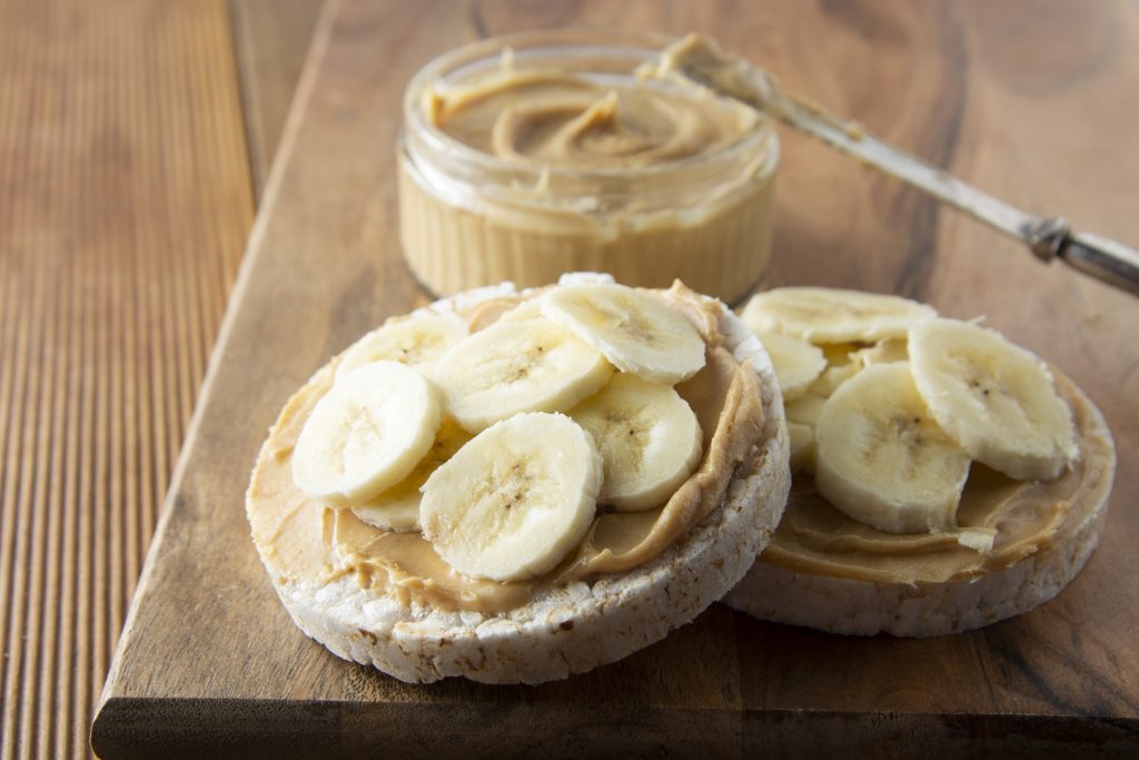 Peanut butter and banana, rice cakes, healthy, dietary food. Wooden background