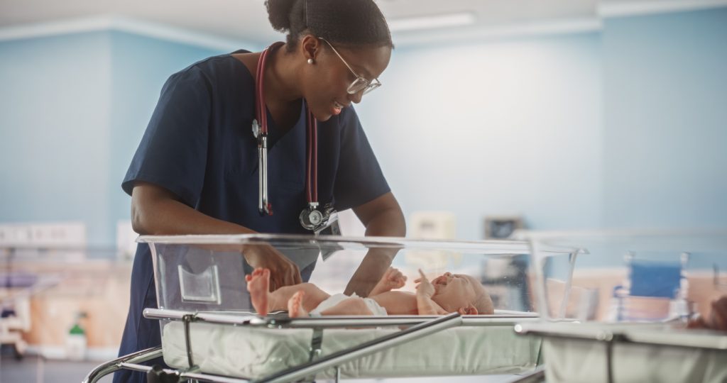 Health care professional aiding a baby in the NICU