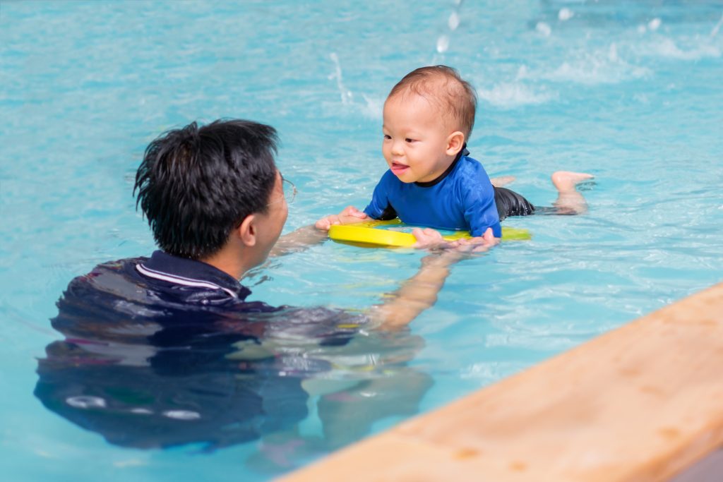 Asian father takes little Asian 18 months / 1 year old toddler baby boy to swimming class