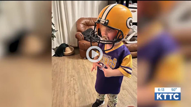 Toddler in a Minnesota Vikings jersey and helmet