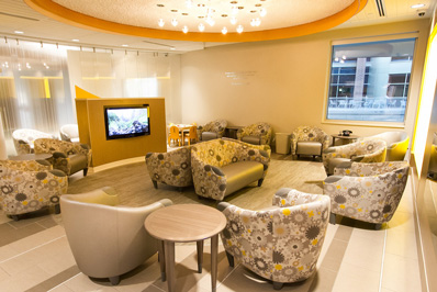 Photograph shows a second waiting area at the St. Paul location. Image shows several chairs and couches and a TV.